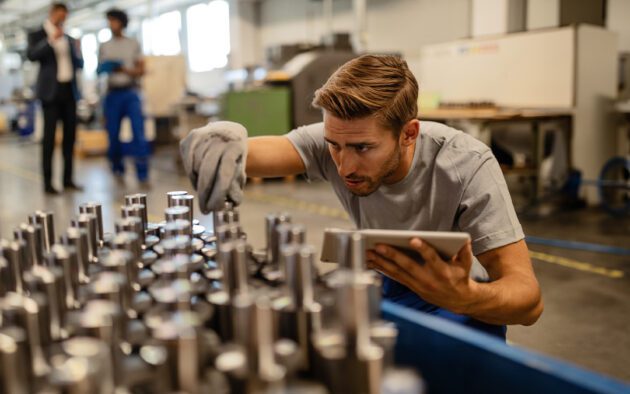 Man with tablet examining a metal product