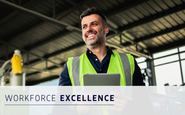 Smiling man in a high-visibility vest holds a tablet in an industrial setting, with the words "Workforce Excellence" displayed at the bottom.