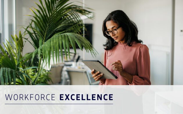 A woman in an office stands near a plant, reading or using a digital tablet. Text on the image reads "Workforce Excellence.