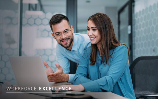 Two people in business attire look at a laptop screen and smile in a modern office setting. The text "Workforce Excellence" appears at the bottom left.