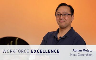 A man wearing glasses and a navy shirt poses with folded arms against an orange background. Text overlay reads: “WORKFORCE EXCELLENCE, Adrian Molato, Next Generation.”