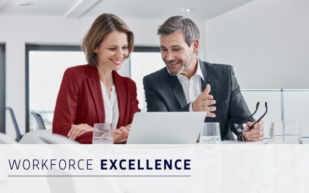 Two business professionals, a woman and a man, sit together at a desk looking at a laptop screen, with the words "Workforce Excellence" displayed at the bottom.