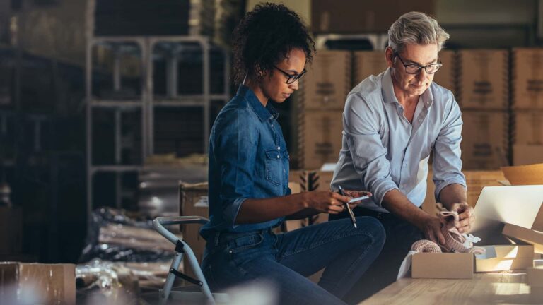 business owners working in warehouse on compliance